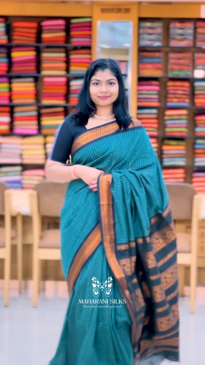 Teal silk saree with copper zari border at the showroom