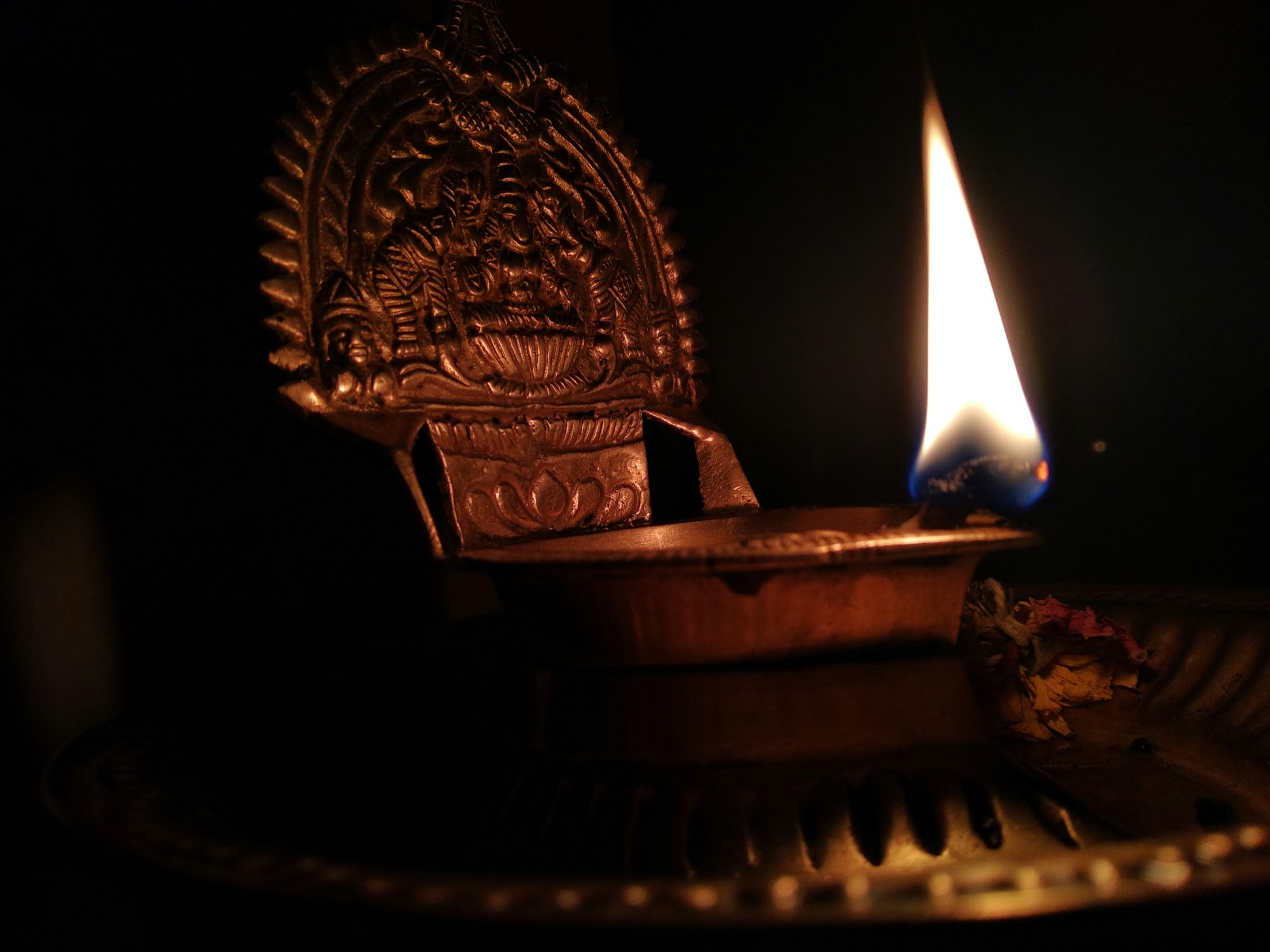 Brass temple lamp with a lit flame